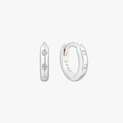 Pair of silver hoop earrings with small diamonds on a white background