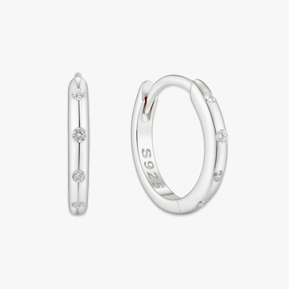 Silver hoop earrings with small diamonds on a white background