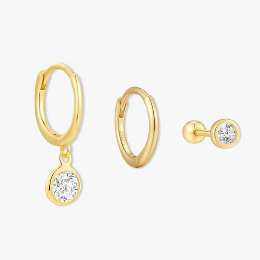 Gold hoop earrings with round gemstones on a white background