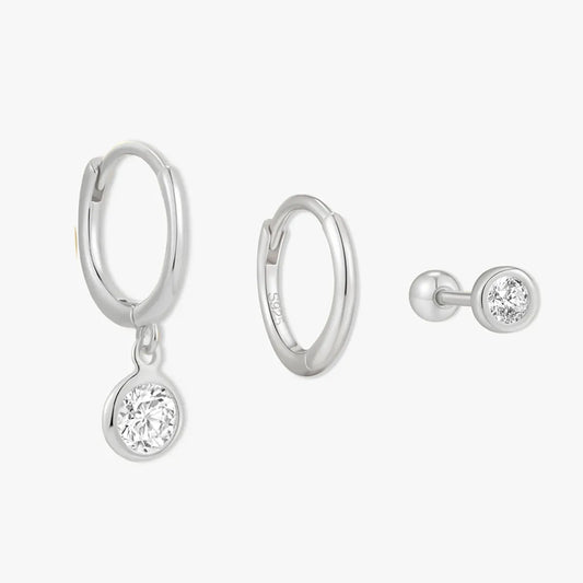 Silver hoop earrings with round gemstones on a white background
