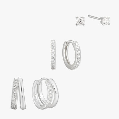 Set of silver hoop earrings and stud earrings on a white background
