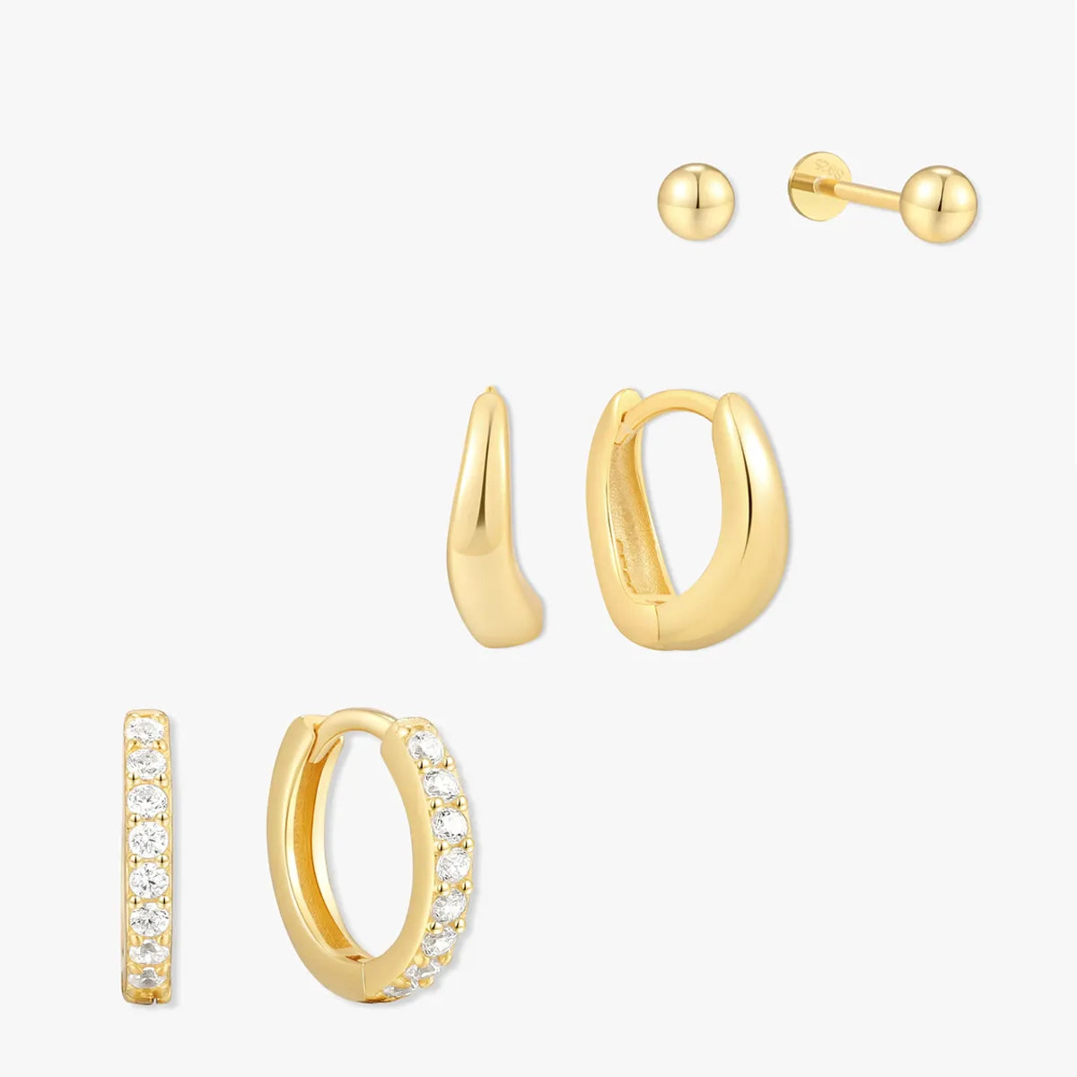 Set of gold hoop earrings with clear stones on a white background