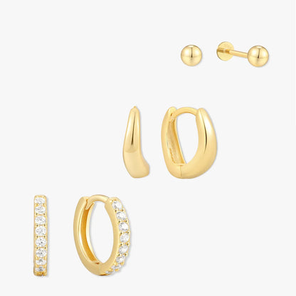 Set of gold hoop earrings with clear stones on a white background
