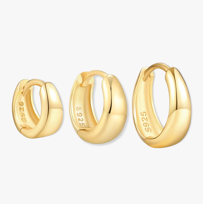 Three gold hoop earrings on a white background