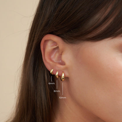 Gold hoop earrings worn by a person with measurements indicated.