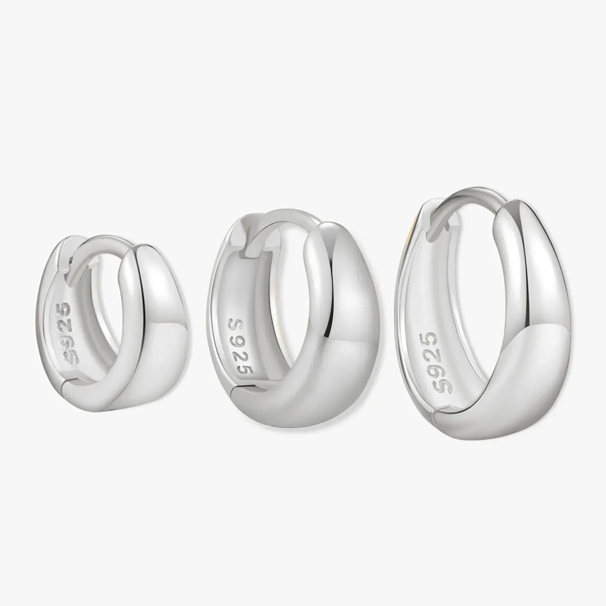 Three silver hoop earrings on a white background