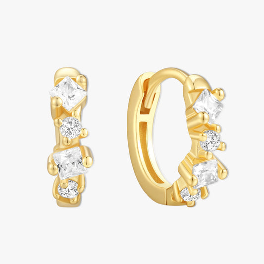 Gold hoop earrings with clear gemstones on a white background
