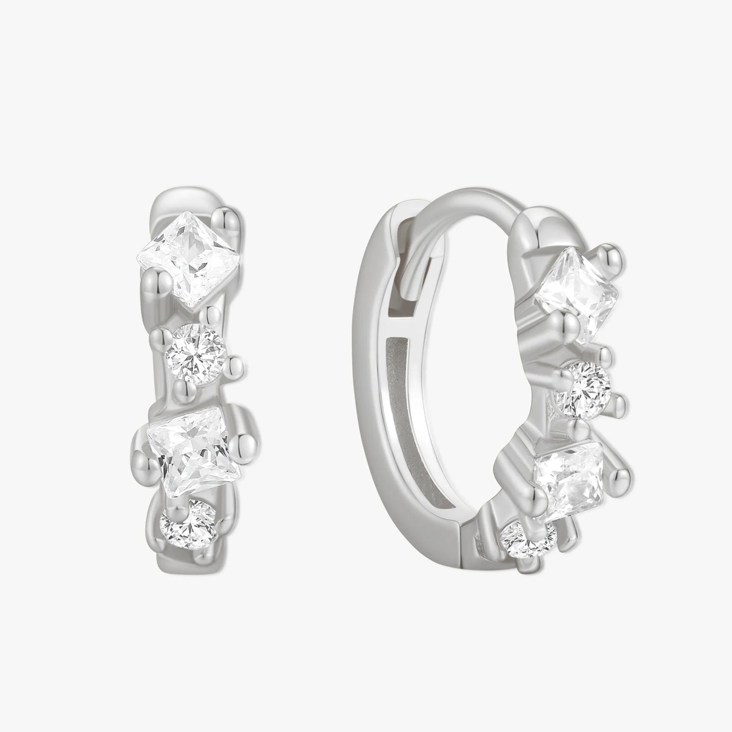 Pair of silver hoop earrings with clear gemstones on a white background