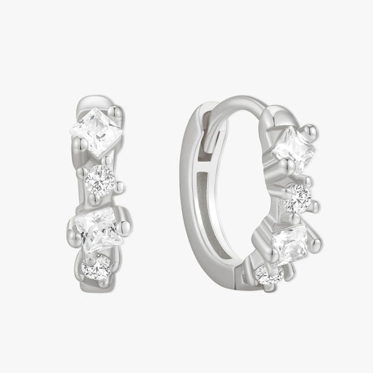 Pair of silver hoop earrings with clear gemstones on a white background