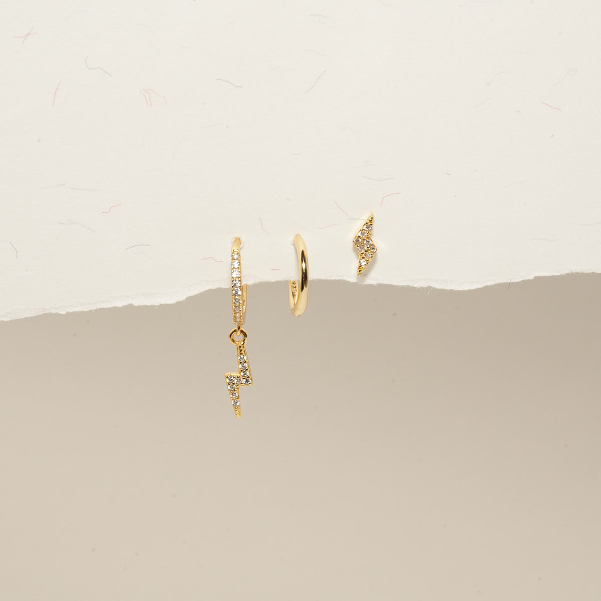 Gold hoop earrings on a beige background