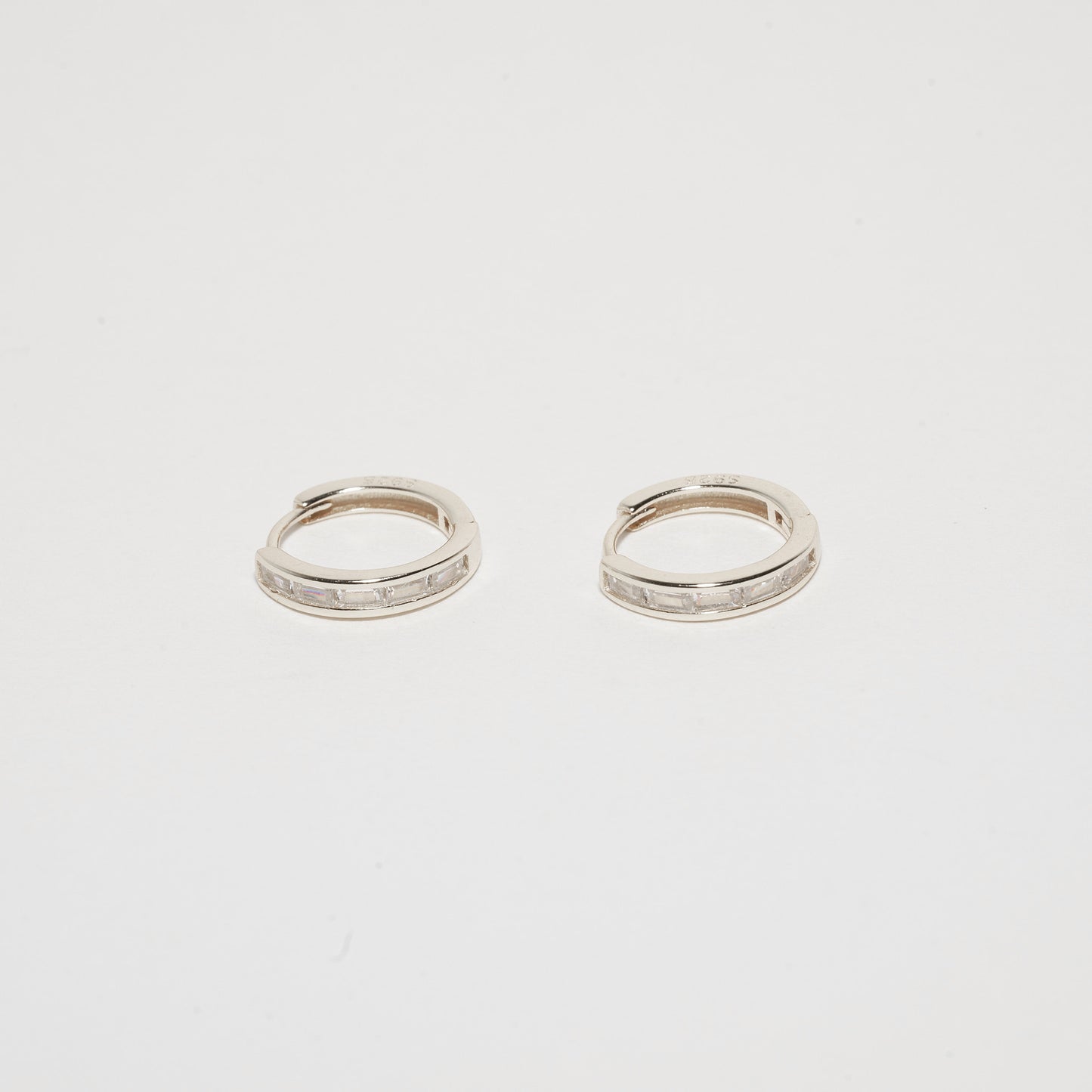 Pair of silver hoop earrings on a light gray background