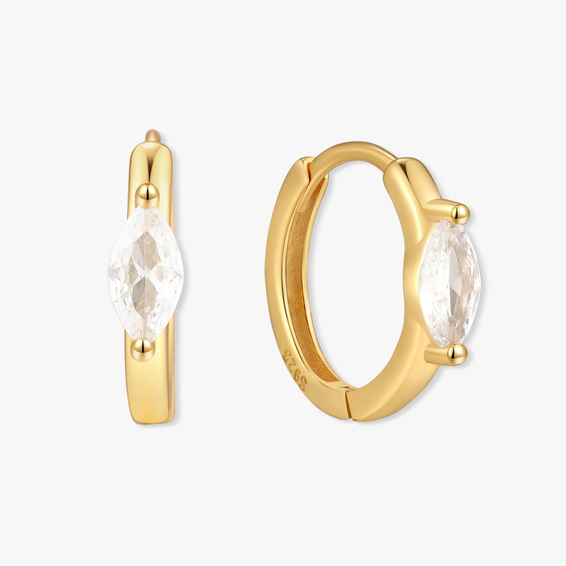 Gold hoop earrings with clear gemstones on a white background