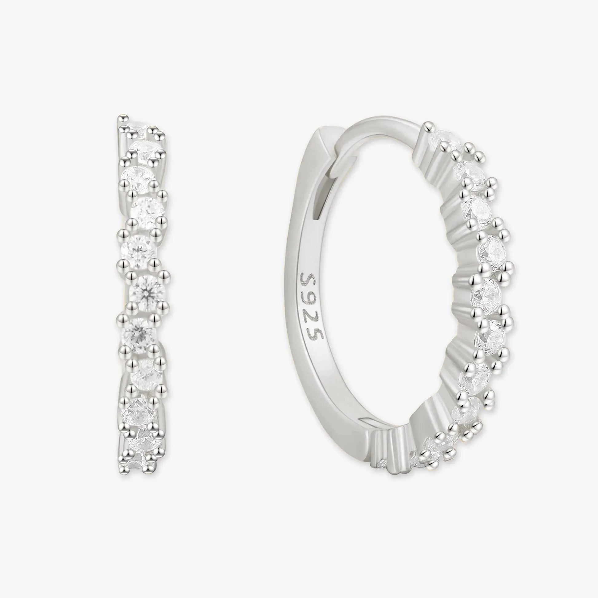 Silver hoop earrings with clear gemstones on a white background
