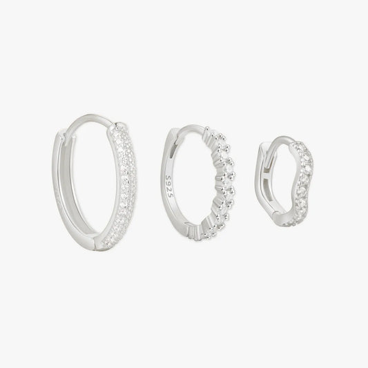 Set of three silver hoop earrings on a white background