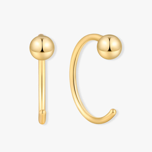 Gold ear cuff with spherical ends on a white background