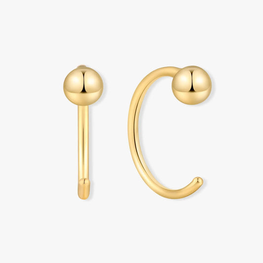 Gold ear cuff with spherical ends on a white background