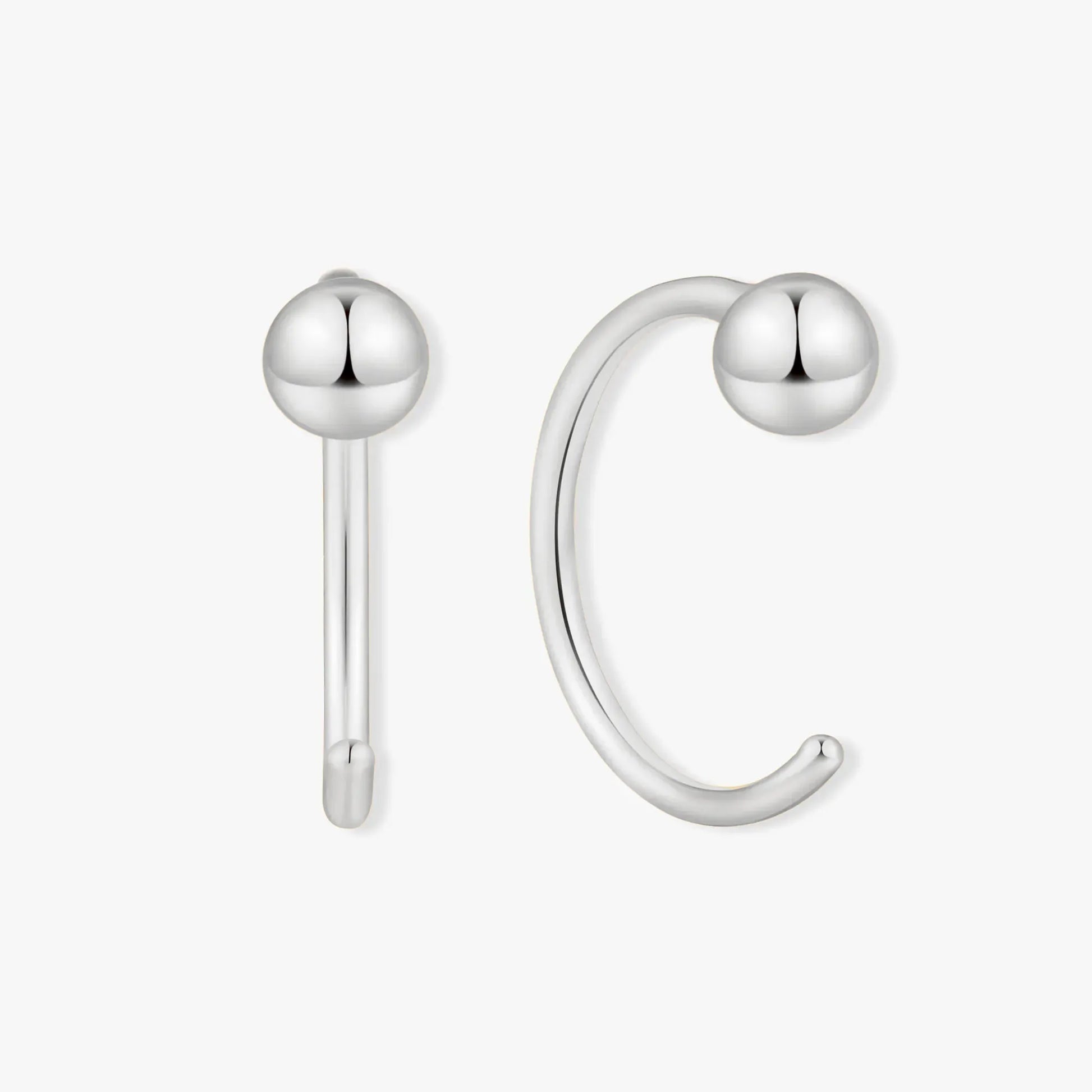 Silver ear cuff with spherical ends on a white background