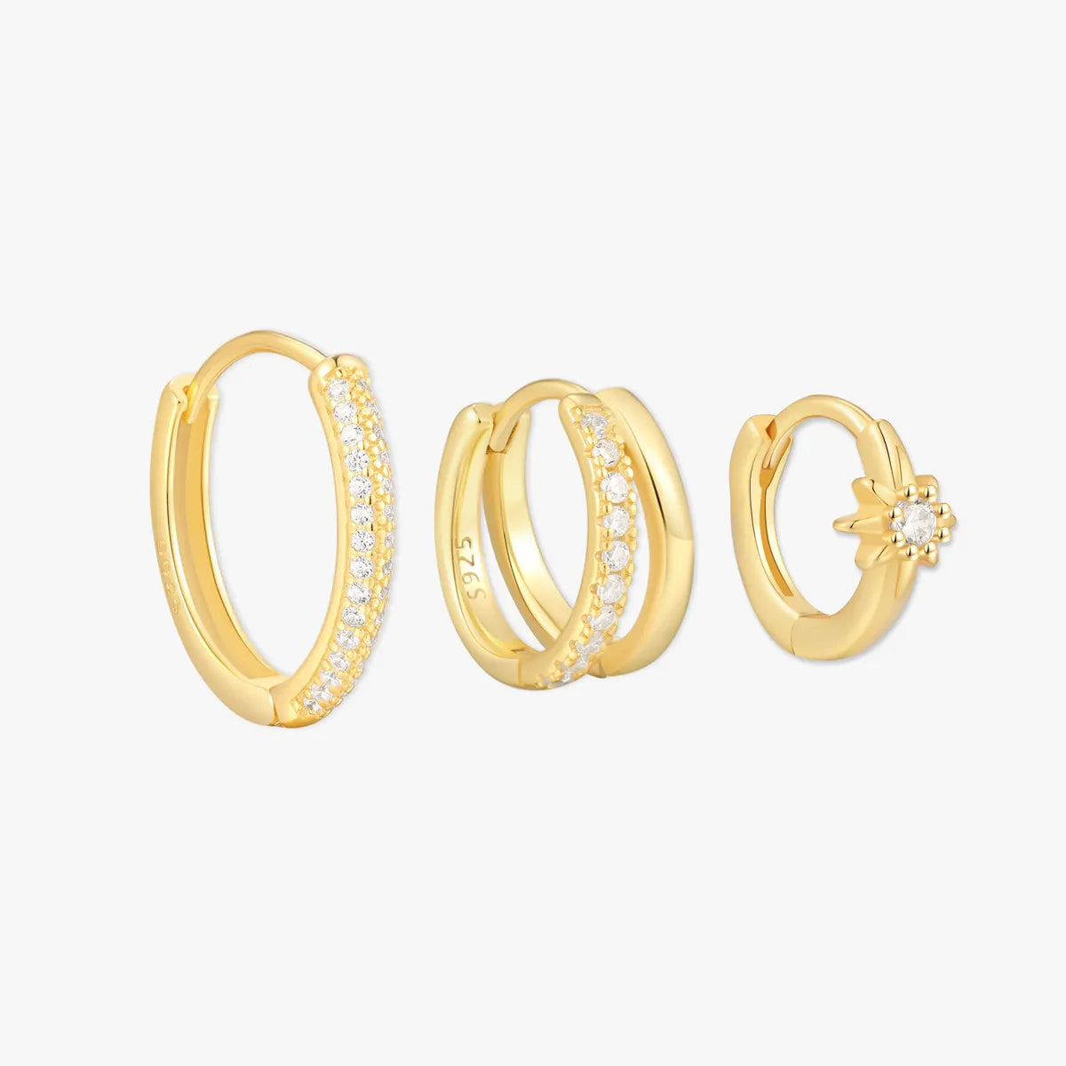 Set of gold hoop earrings on a white background