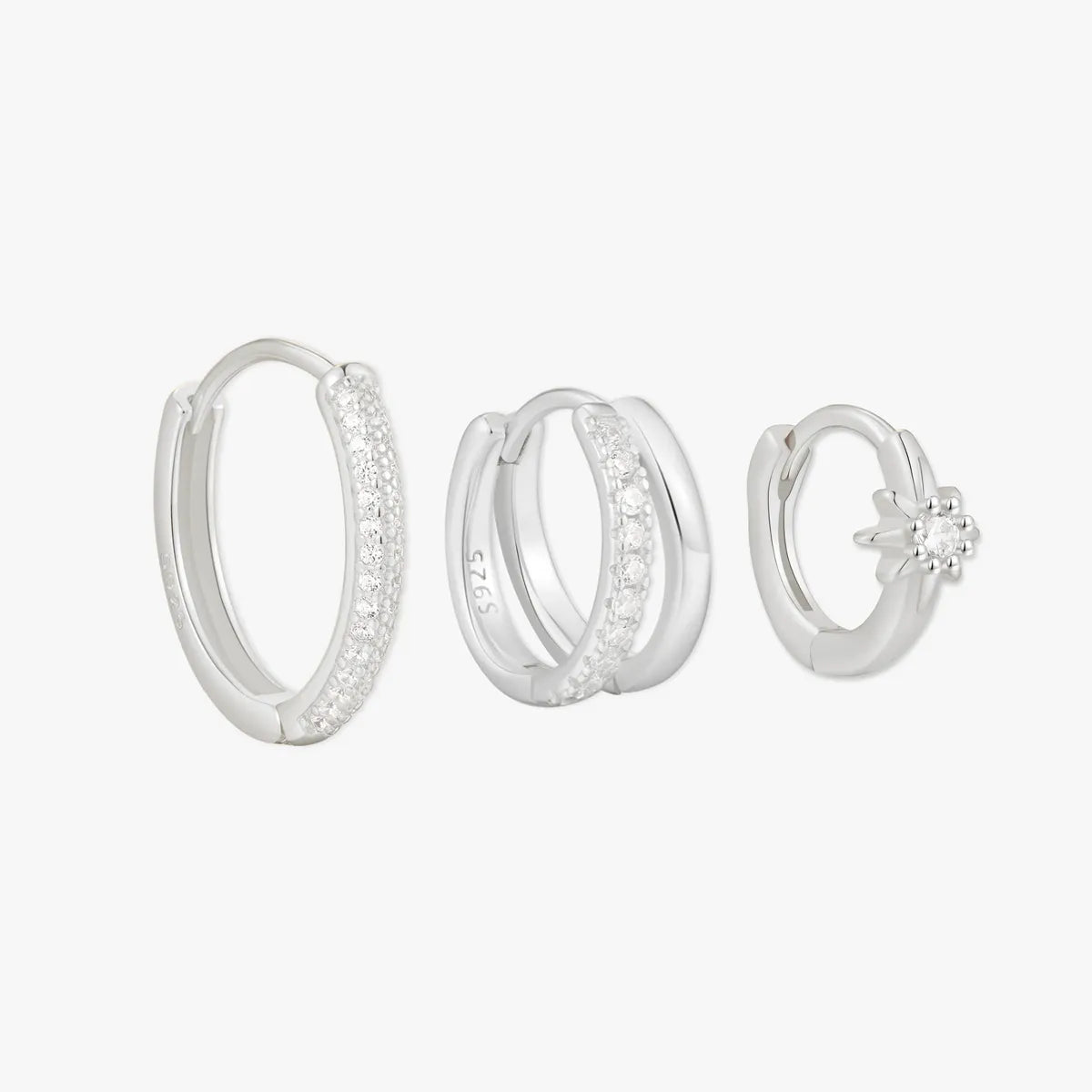 Set of three silver hoop earrings on a white background