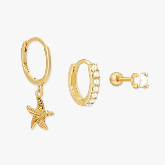 Gold hoop earrings with starfish charm and pearl detail on a white background