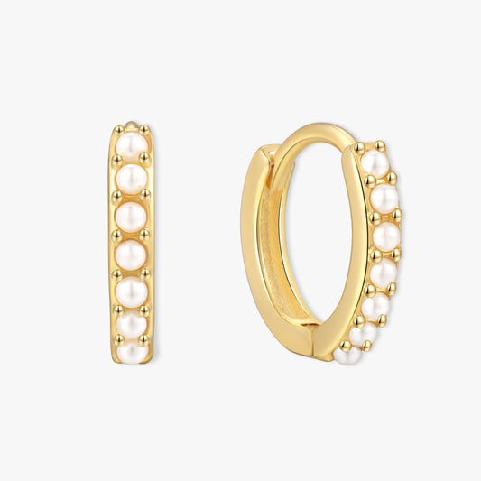 Gold hoop earrings with pearl accents on a white background