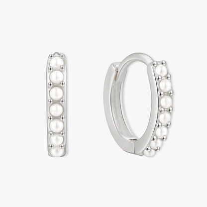 Silver hoop earrings with pearl-like beads on a white background
