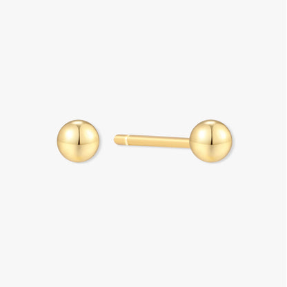 Gold ball earrings on a white background