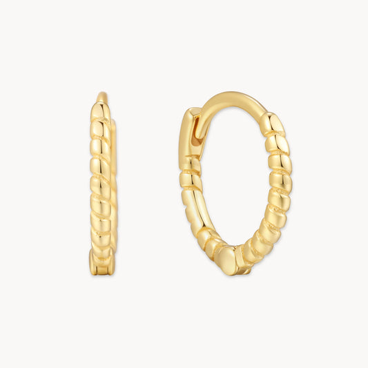 Gold hoop earrings with textured design on a white background