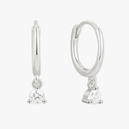 Silver hoop earrings with round-shaped gemstones on a white background