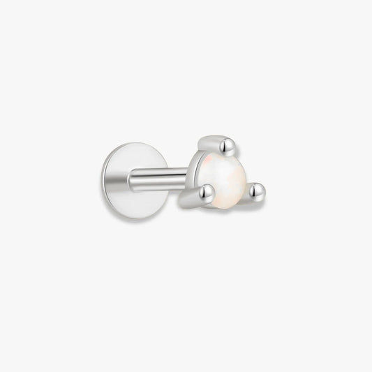 Single stud earring with a white gemstone on a light beige background