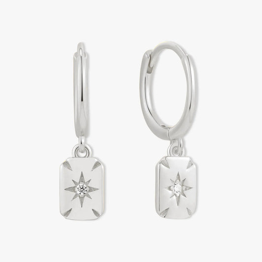 Pair of silver hoop earrings with star-shaped charms on a white background