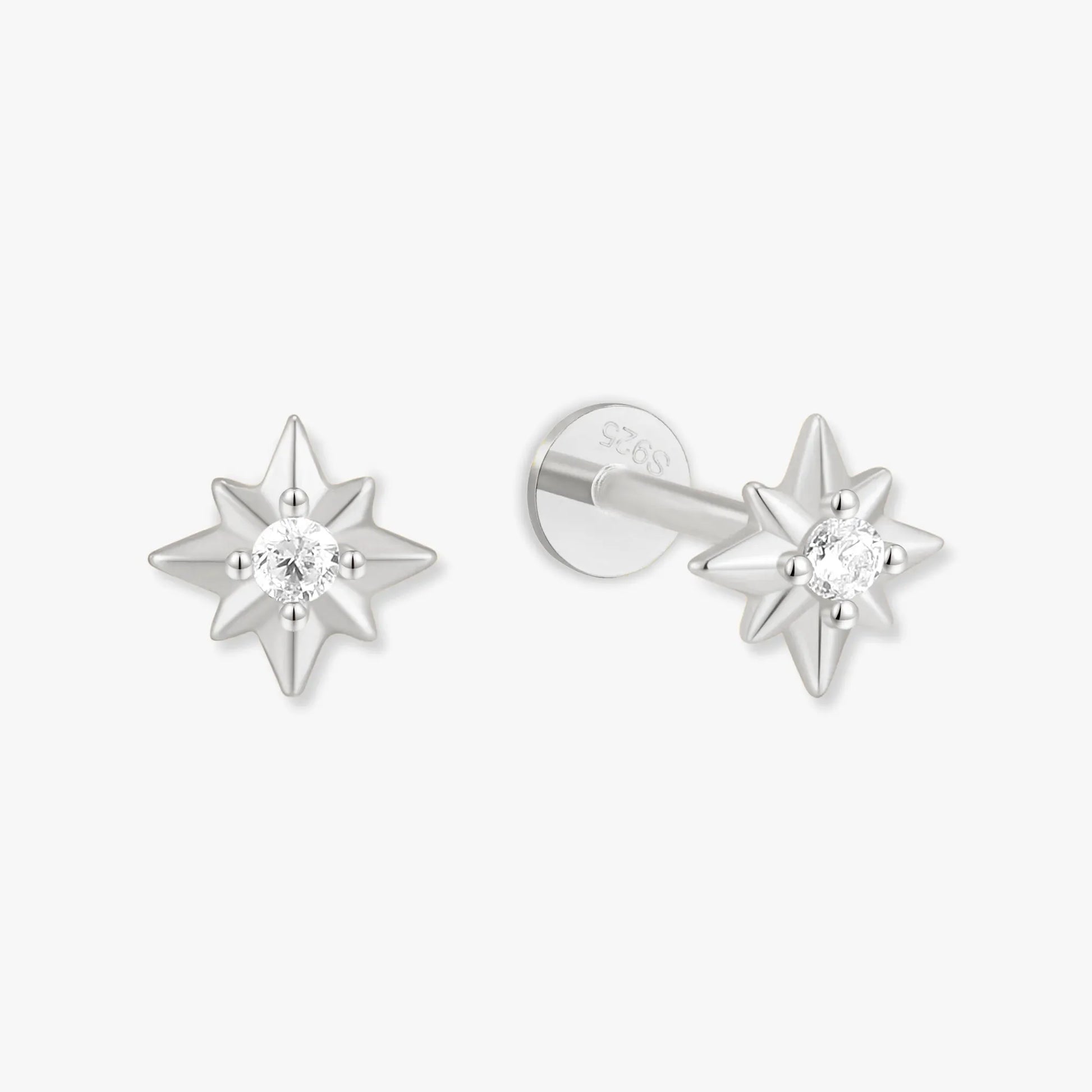 Star-shaped silver earrings with clear gemstones on a white background