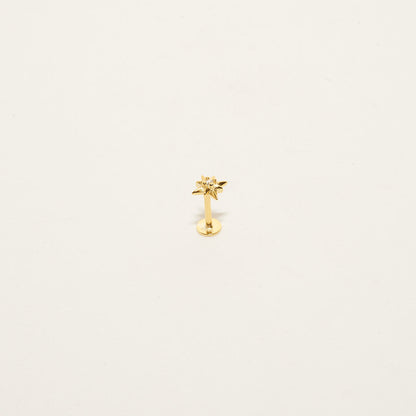 Gold-colored earring on a light beige background