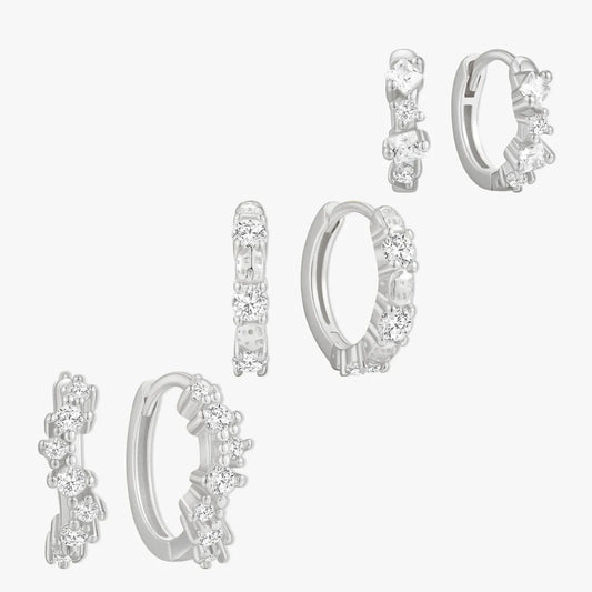 Set of silver hoop earrings with clear gemstones on a white background