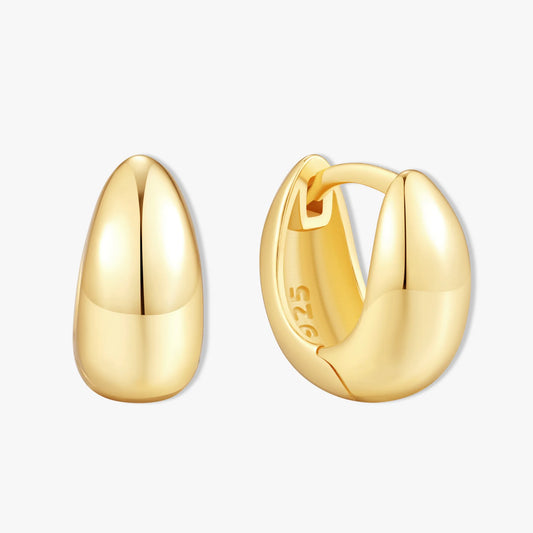 Gold hoop earrings on a light gray background