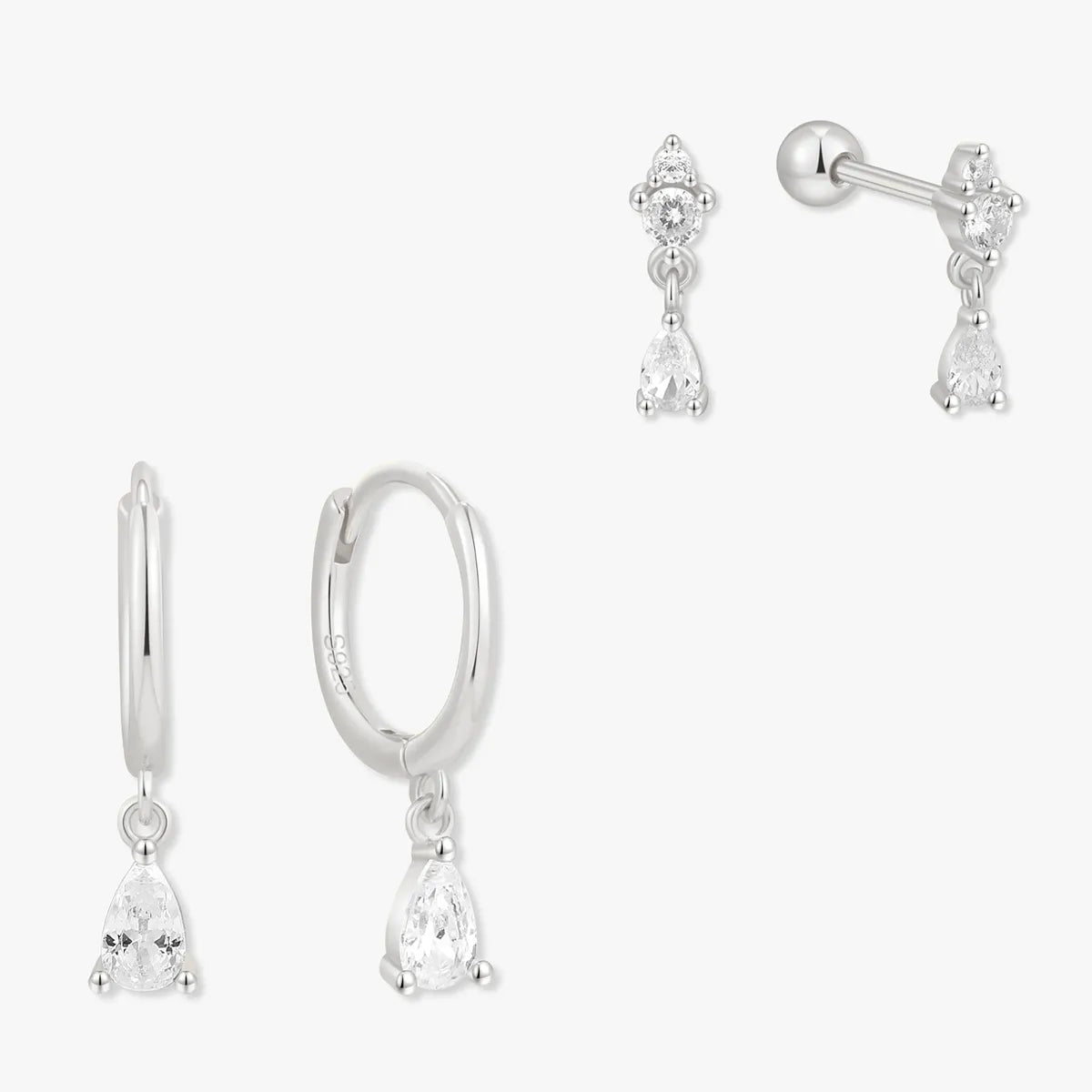 Set of silver earrings including teardrop, hoop, and bow designs on a white background