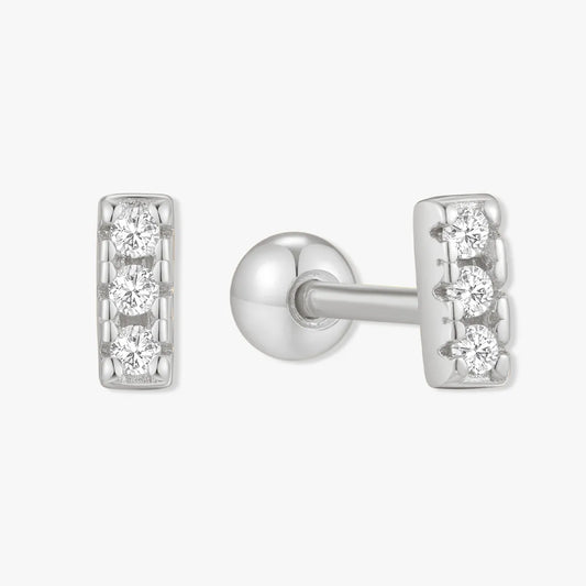 Silver earring with clear gemstones on a white background