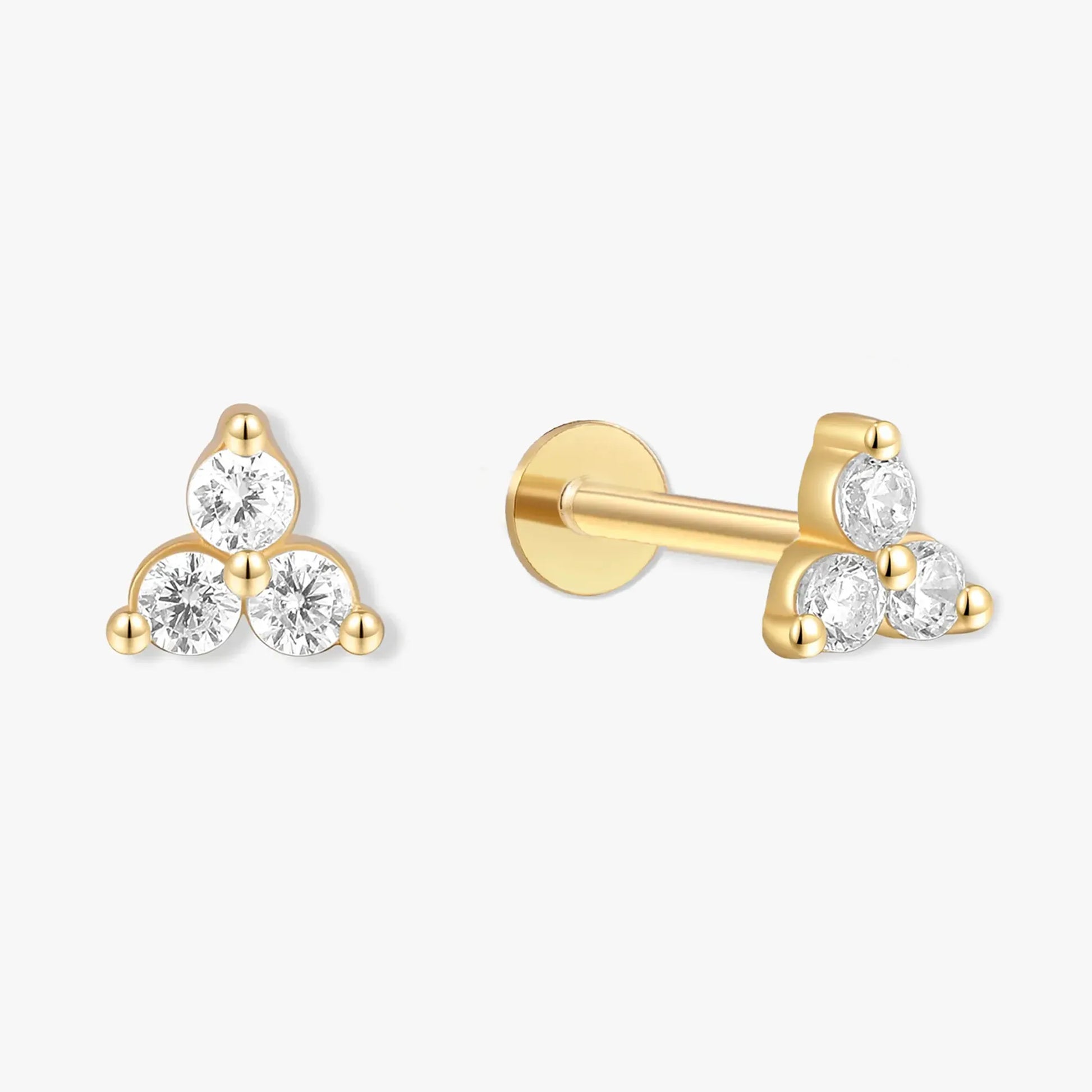 Gold earrings with clear gemstones on a white background