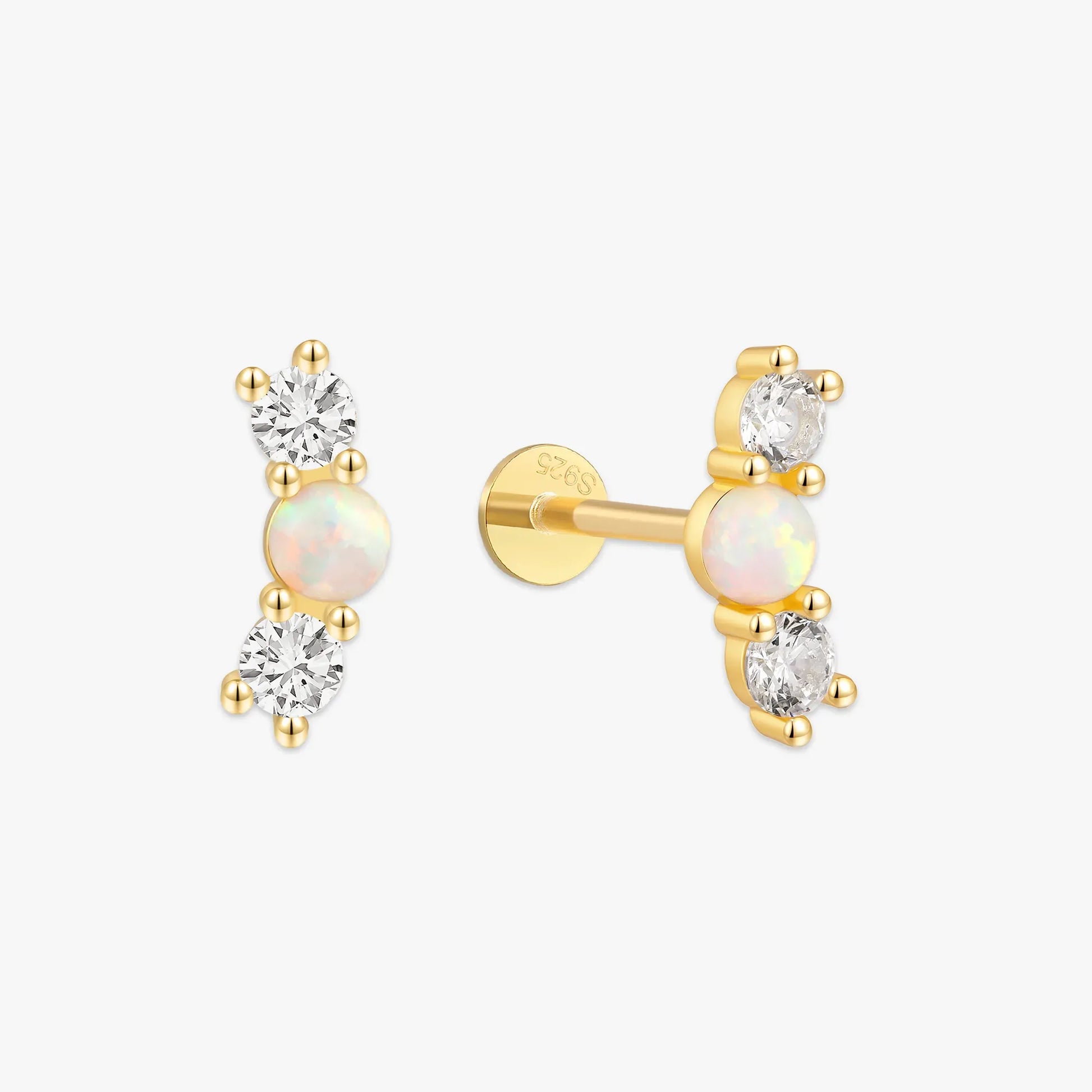 Pair of gold earrings with opal and diamond stones on a white background