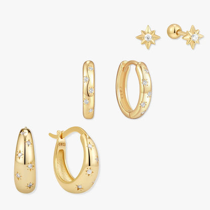 Set of gold earrings including hoop and star designs on a white background