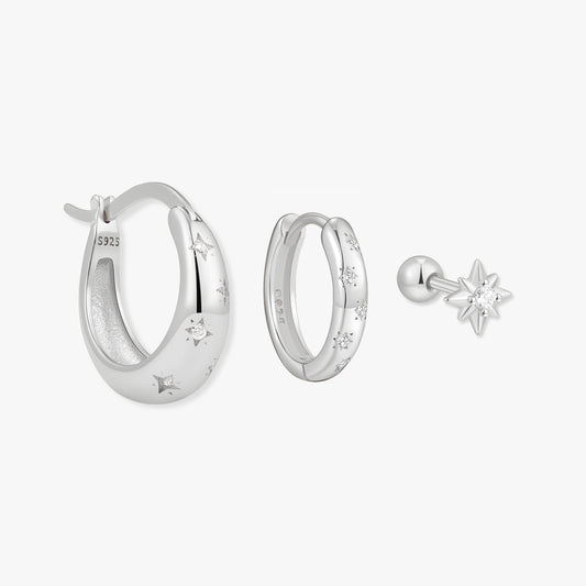 Silver hoop earrings and a star-shaped earring on a white background