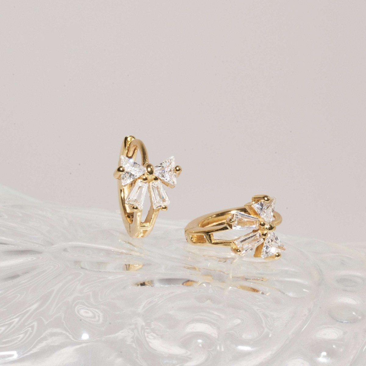 Crystal Bow Huggie Hoops In Gold - LÉA