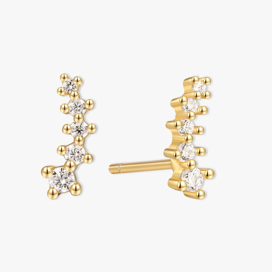 Gold earrings with diamond-like stones on a white background