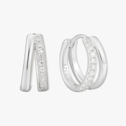 Silver double hoop earrings with embedded stones on a white background