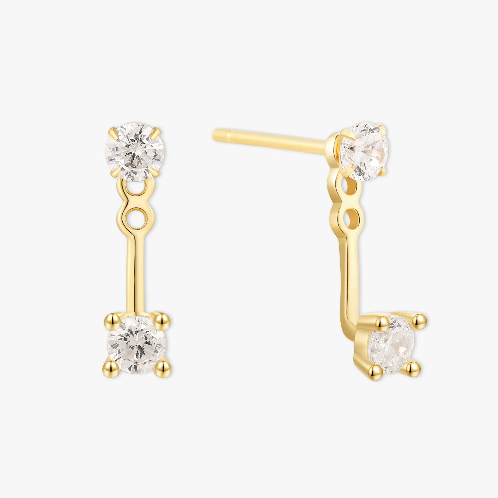 Gold earrings with clear gemstones on a white background