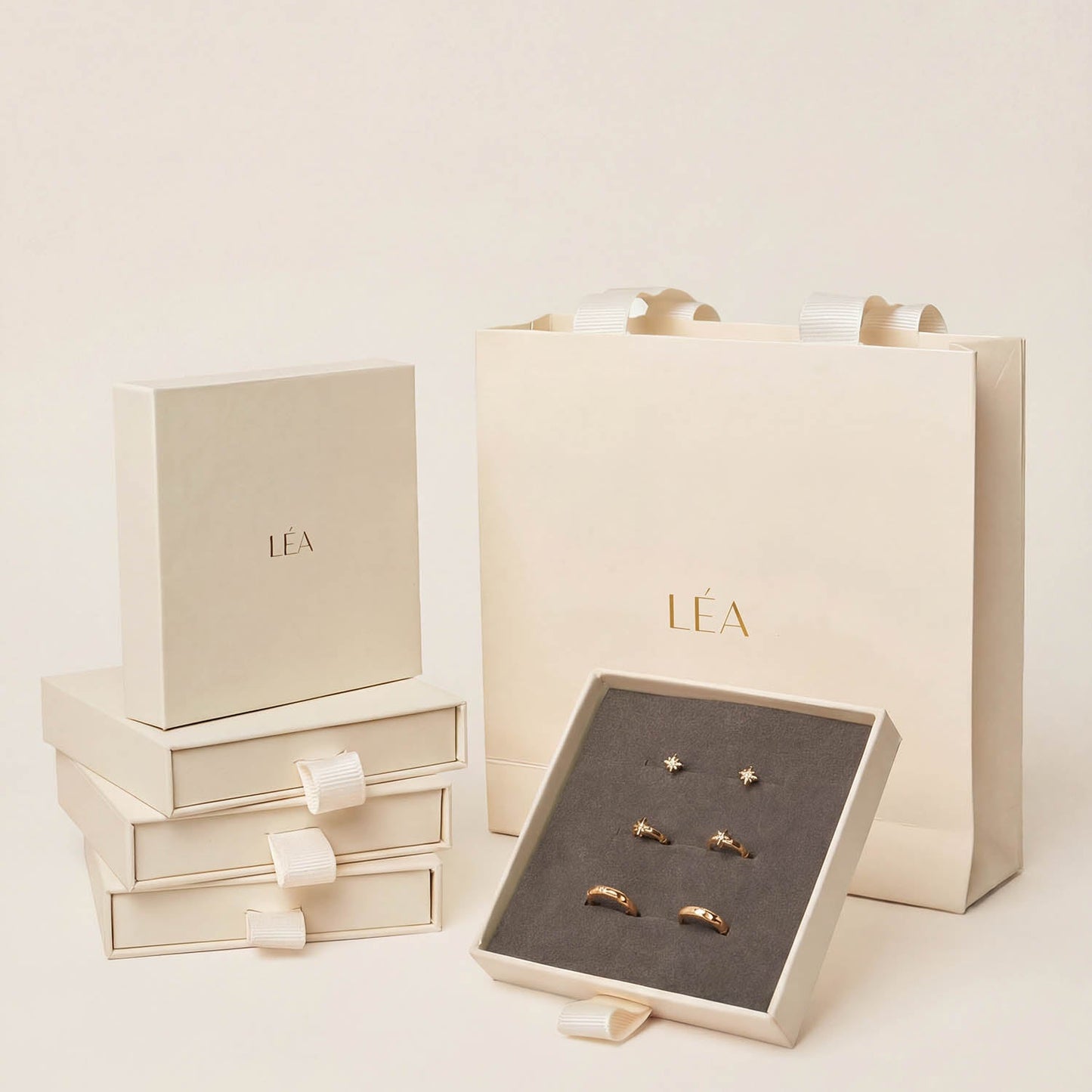 Jewelry set with 'LEA' branded box and packaging on a light background