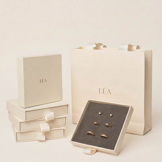 Jewelry set with 'LEA' branded box and packaging on a light background