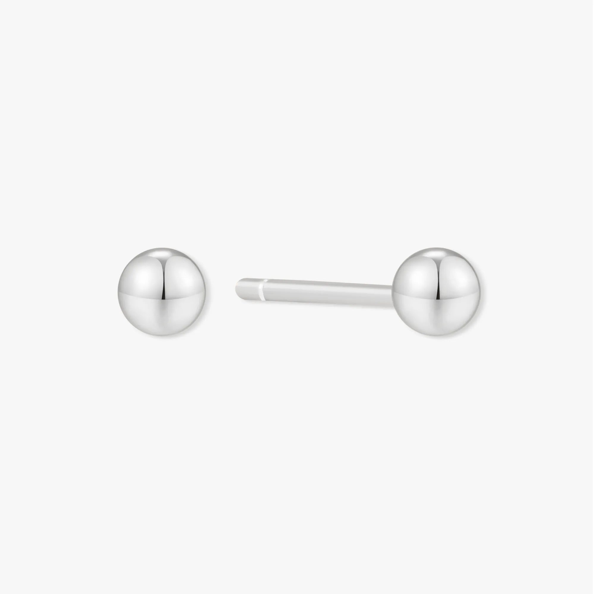 Pair of silver ball earrings on a white background