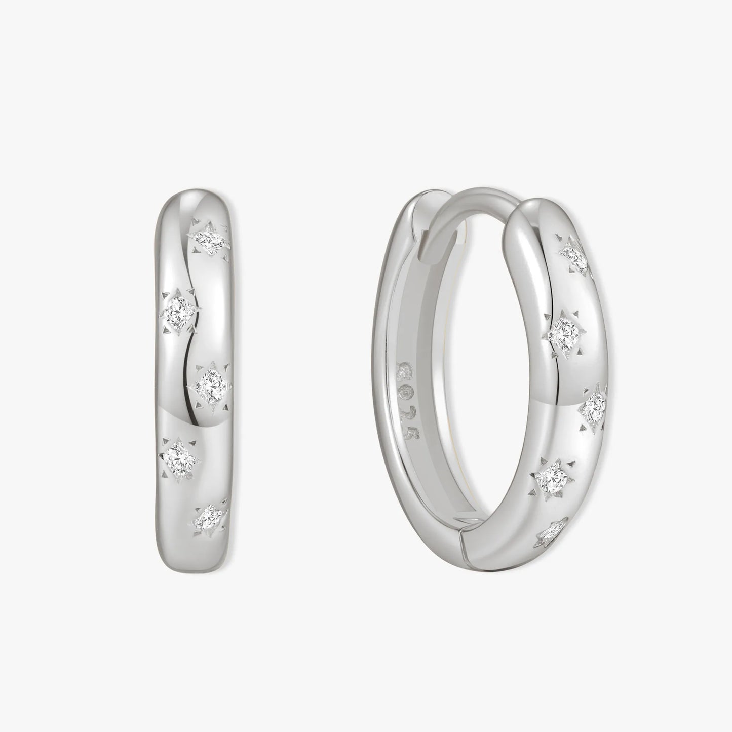 Silver hoop earrings with embedded diamonds on a white background
