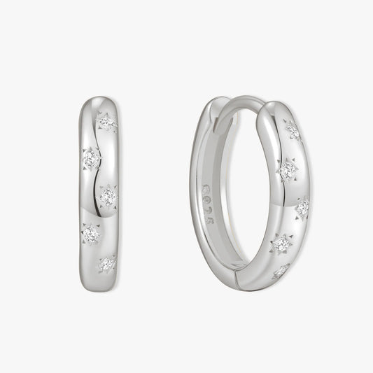 Silver hoop earrings with embedded diamonds on a white background